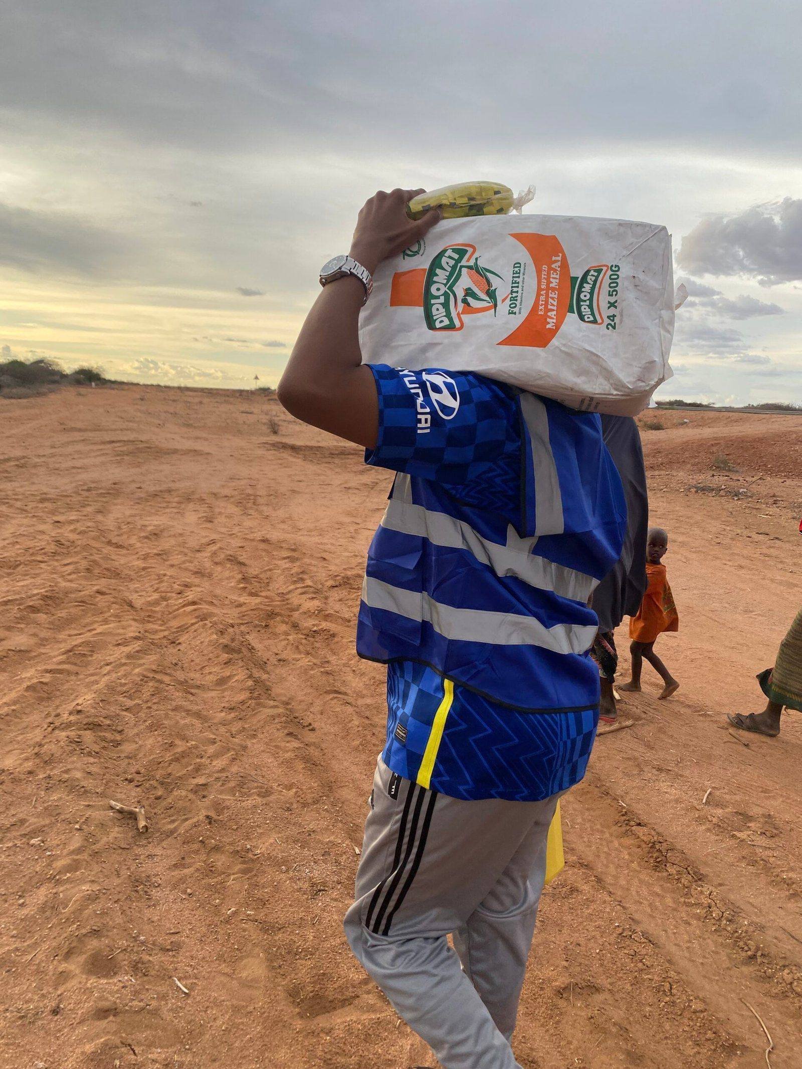 A volunteer carrying a food pack